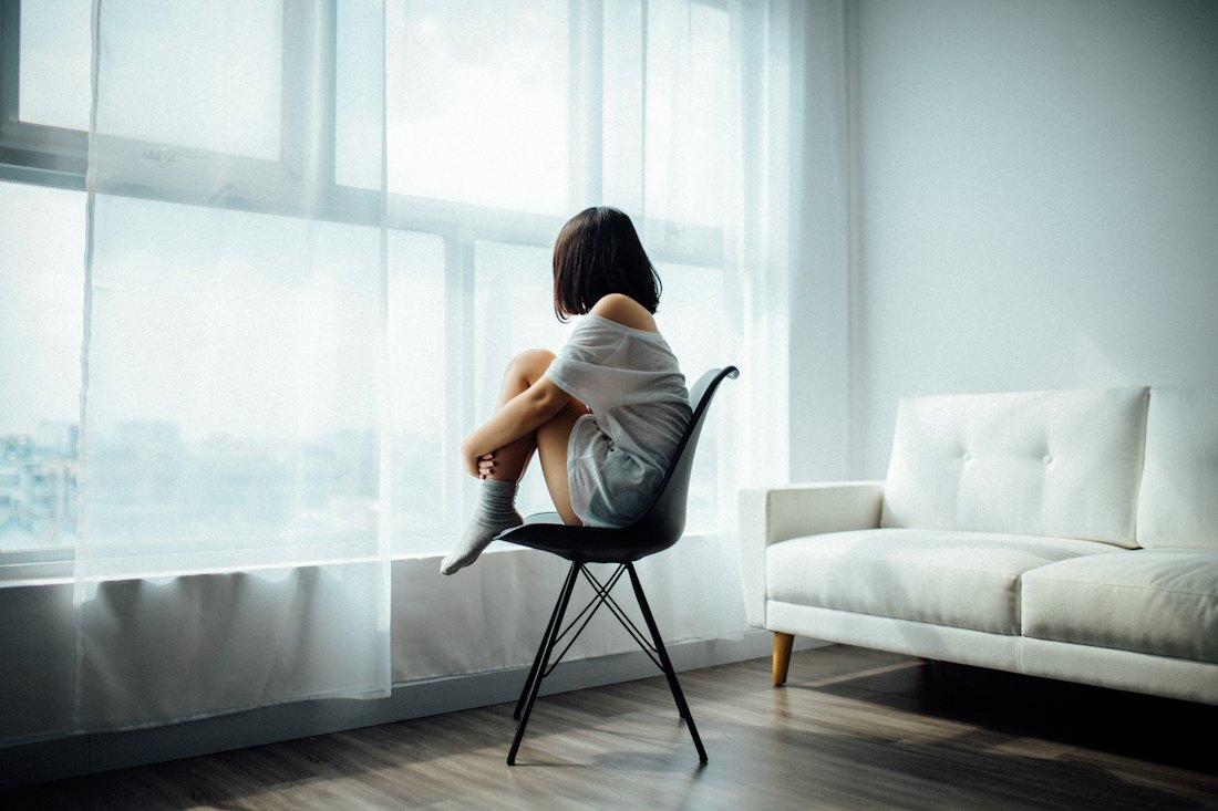 A woman sitting quietly by a sunlit window